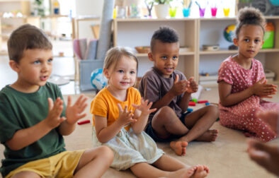 group-small-nursery-school-children-sitting-floor-indoors-classroom-clapping